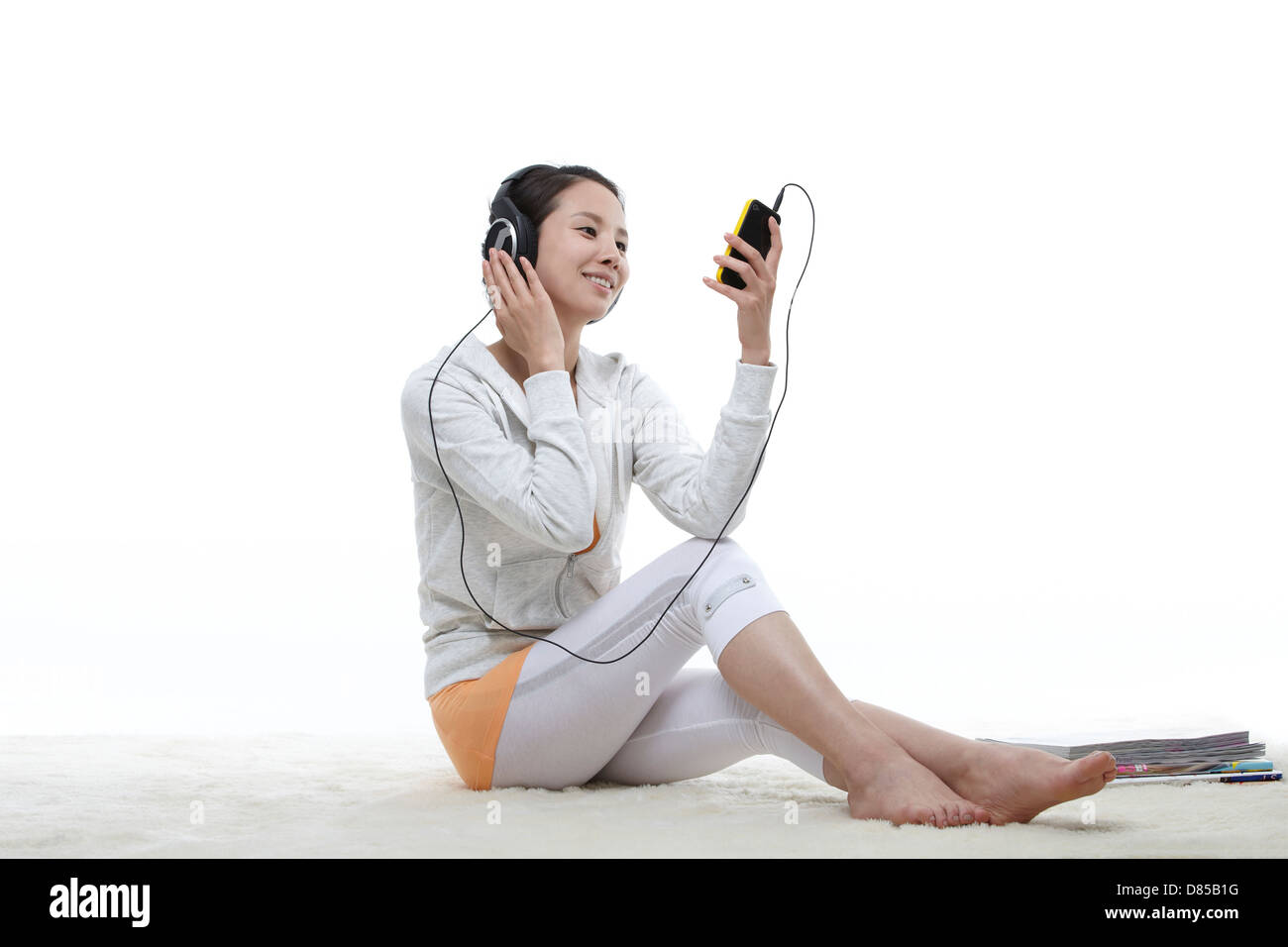 young woman sitting listening to music Stock Photo - Alamy