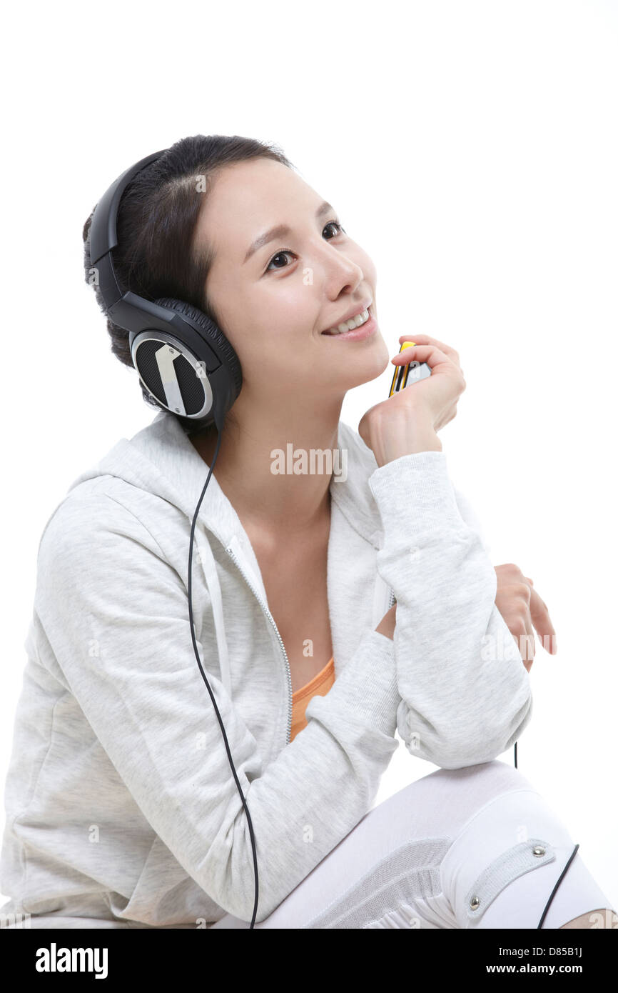young woman sitting listening to music Stock Photo - Alamy