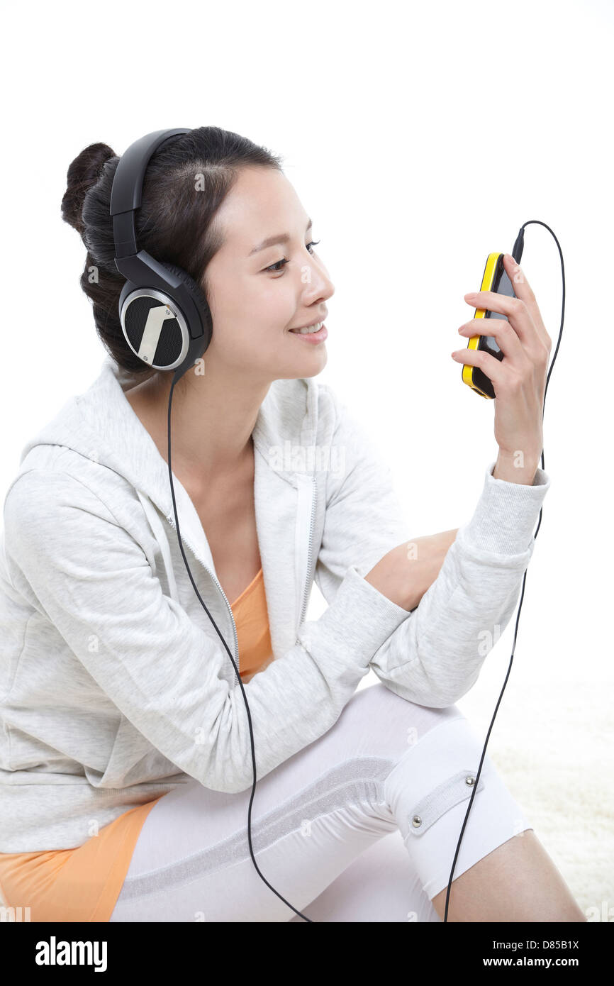 young woman sitting listening to music Stock Photo - Alamy
