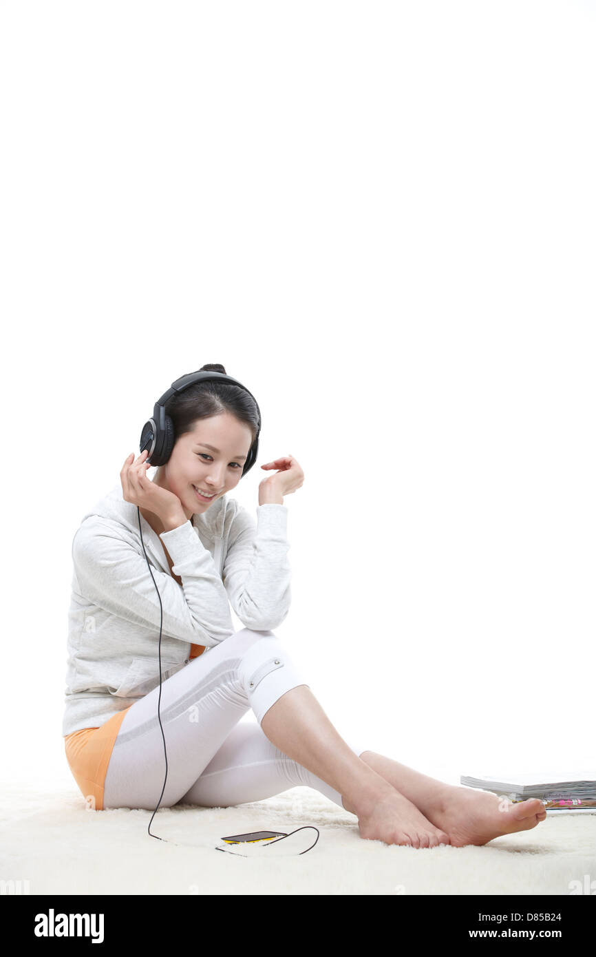 young woman sitting listening to music Stock Photo - Alamy