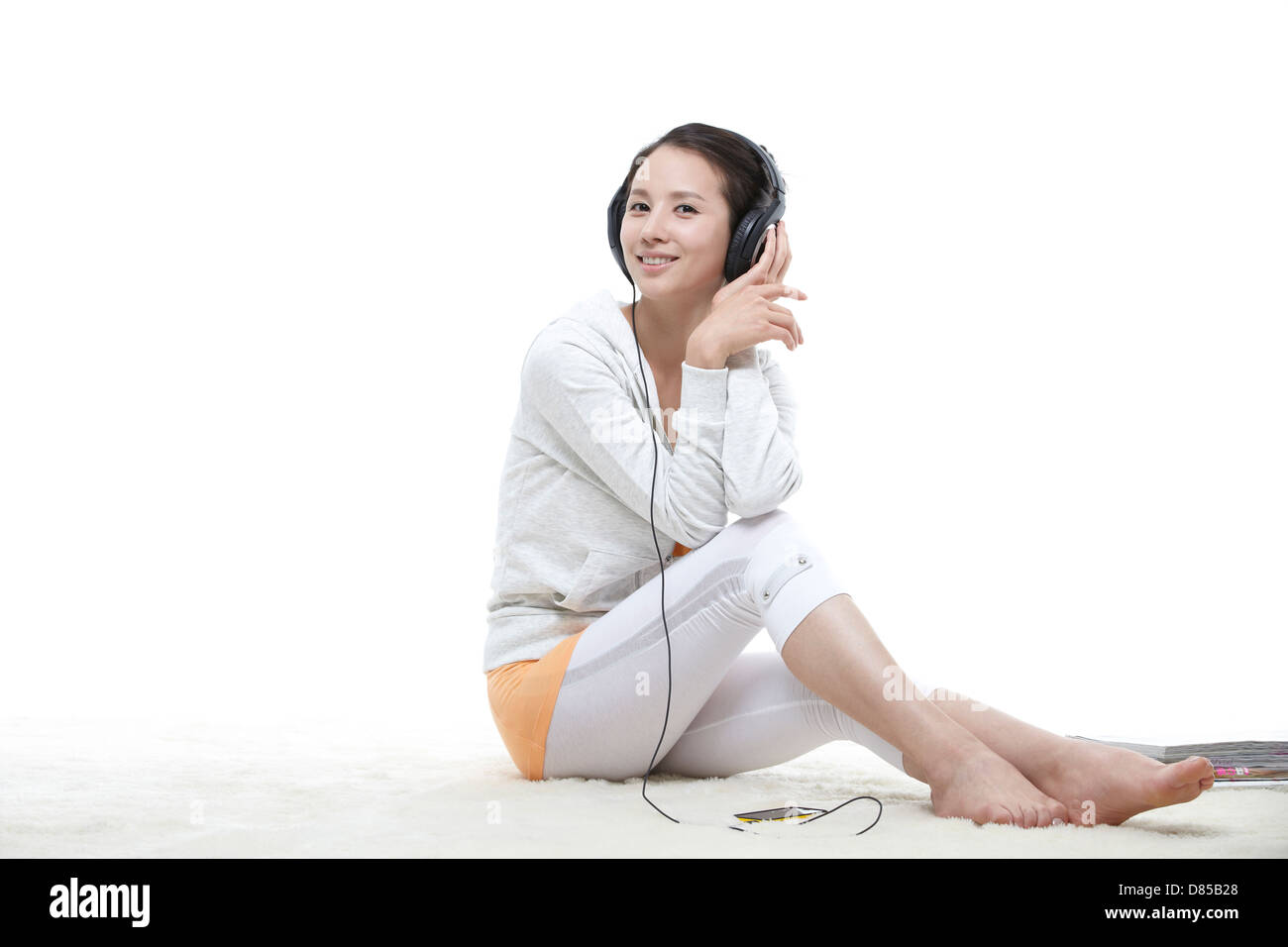 young woman sitting listening to music Stock Photo - Alamy