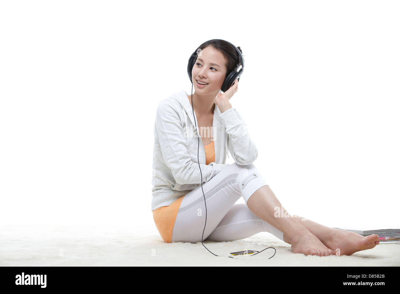 young woman sitting listening to music. Stock Photo