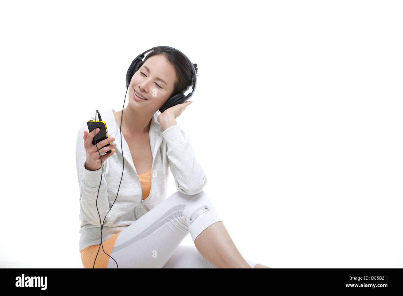 young woman sitting listening to music Stock Photo - Alamy