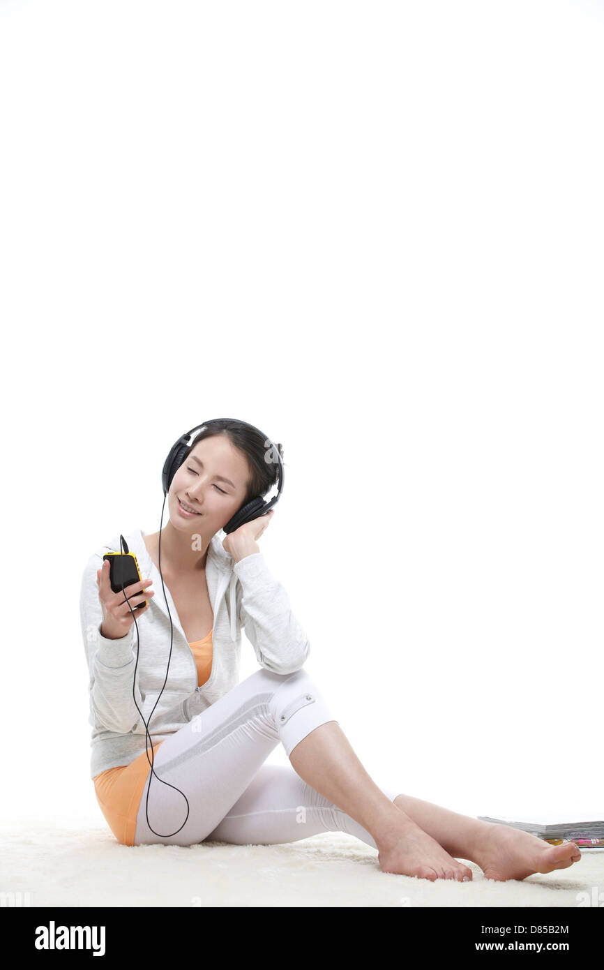 young woman sitting listening to music Stock Photo - Alamy