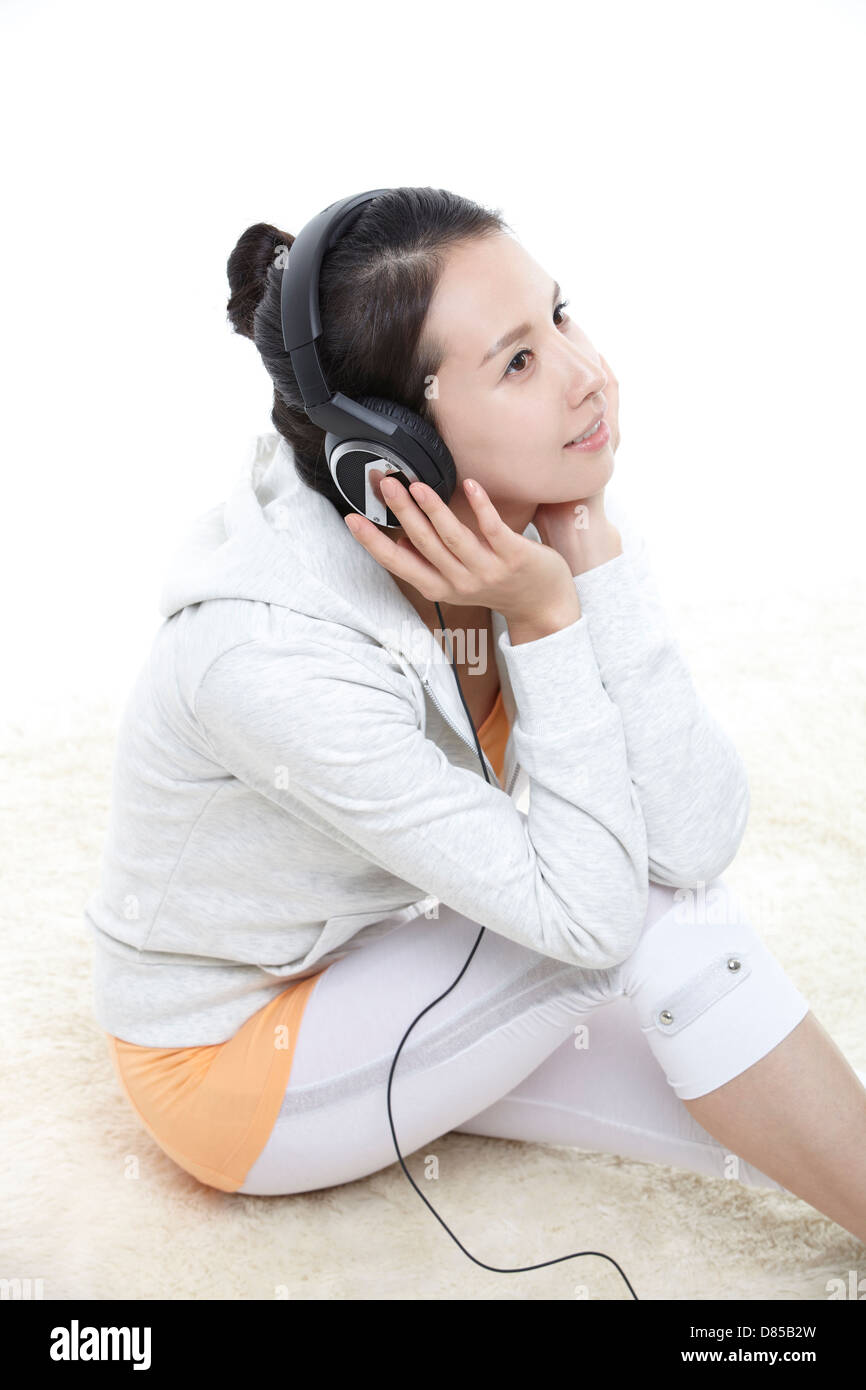 young woman sitting listening to music Stock Photo - Alamy