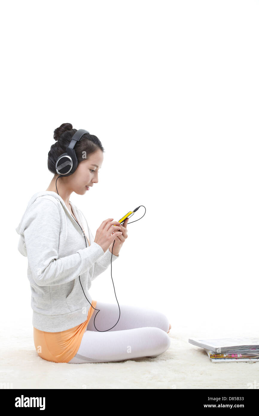 young woman sitting listening to music Stock Photo - Alamy