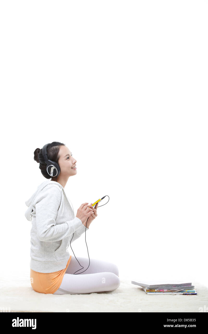 young woman sitting listening to music Stock Photo - Alamy