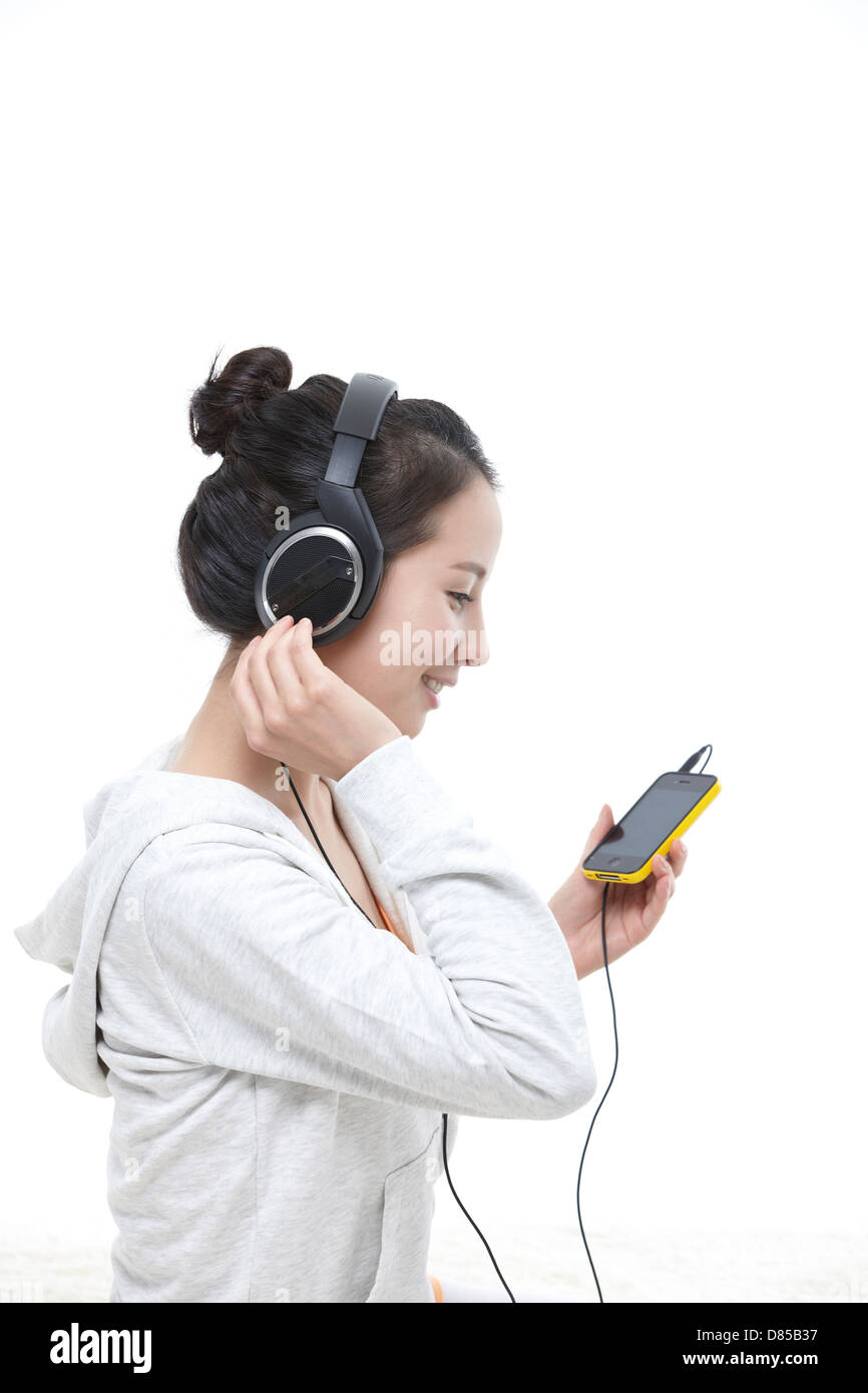 young woman sitting listening to music Stock Photo - Alamy