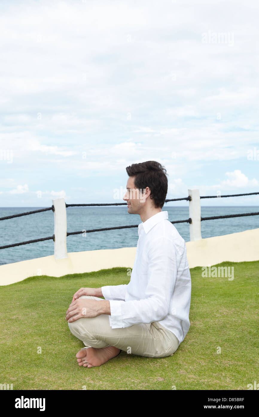 man sitting cross-legged meditating Stock Photo - Alamy