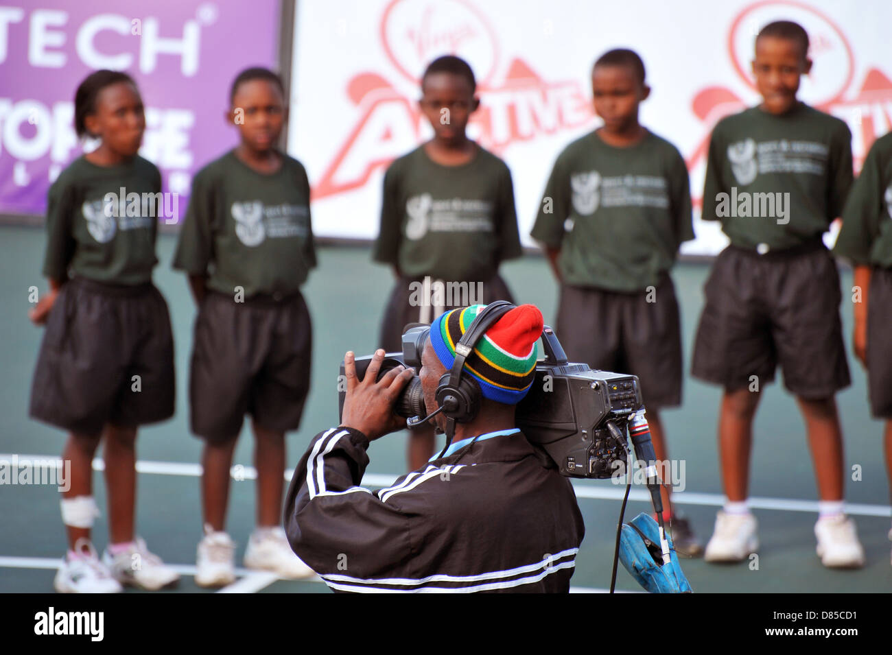 A cameraman wearing a South African flag hat filming at the 2013 Soweto