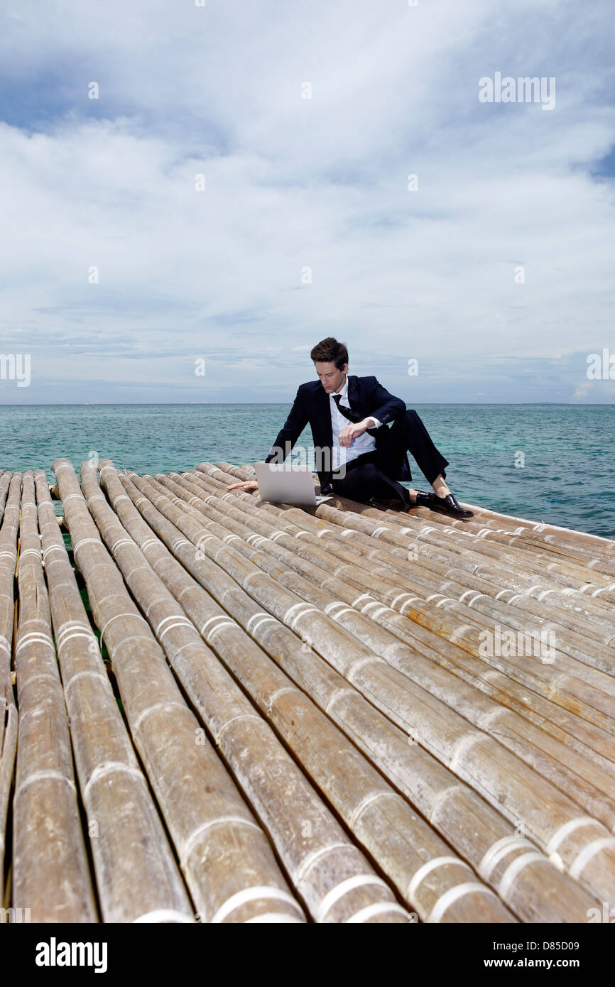 businessman sitting on dock laptop. Stock Photo