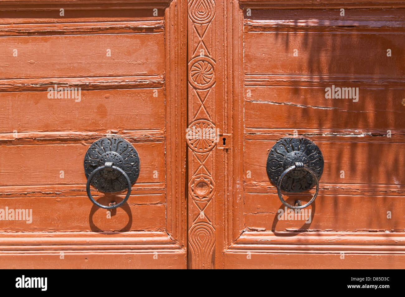 Detailed view of a double wooden door with iron door knobs, Rethymno