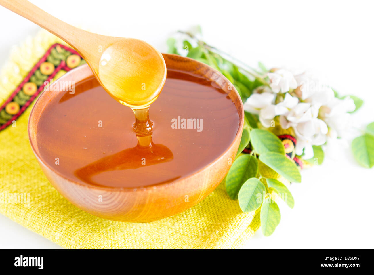 Honey in wooden bowl and acacia plant Stock Photo