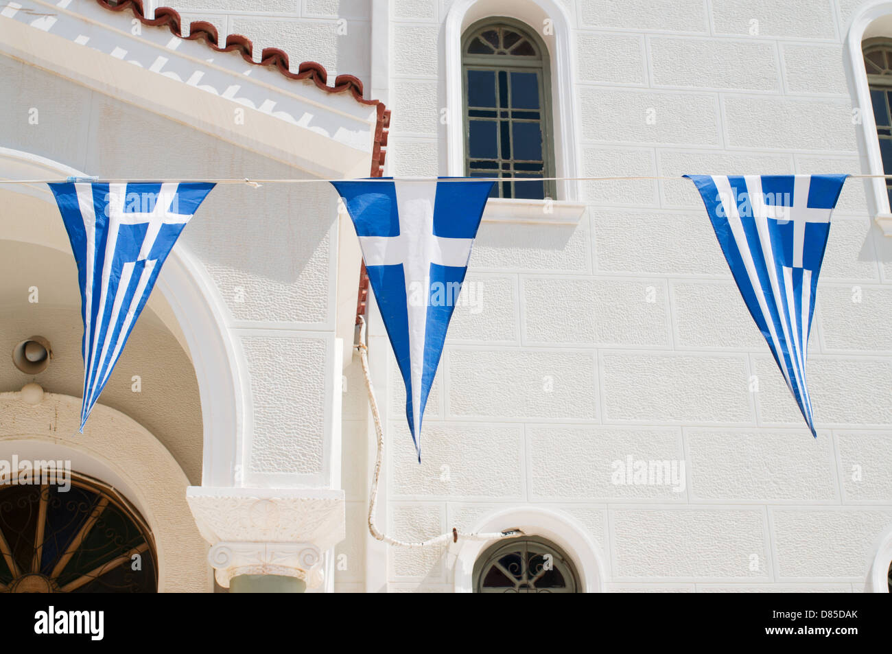 Greek flags fly outside the church of Metropolis Rethymno Stock Photo