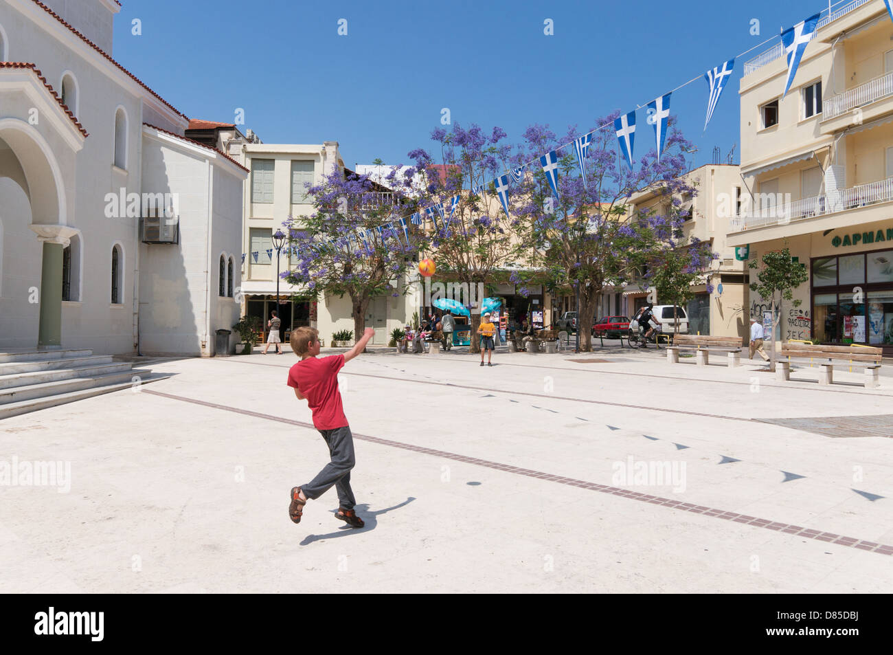 Two young boys playing with a ball within Mitropolis square in Rethymno, Crete Stock Photo