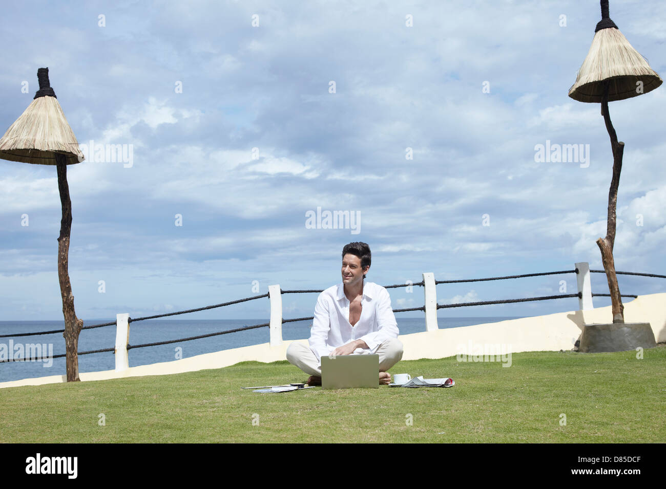 man sitting cross-legged on grass laptop Stock Photo - Alamy