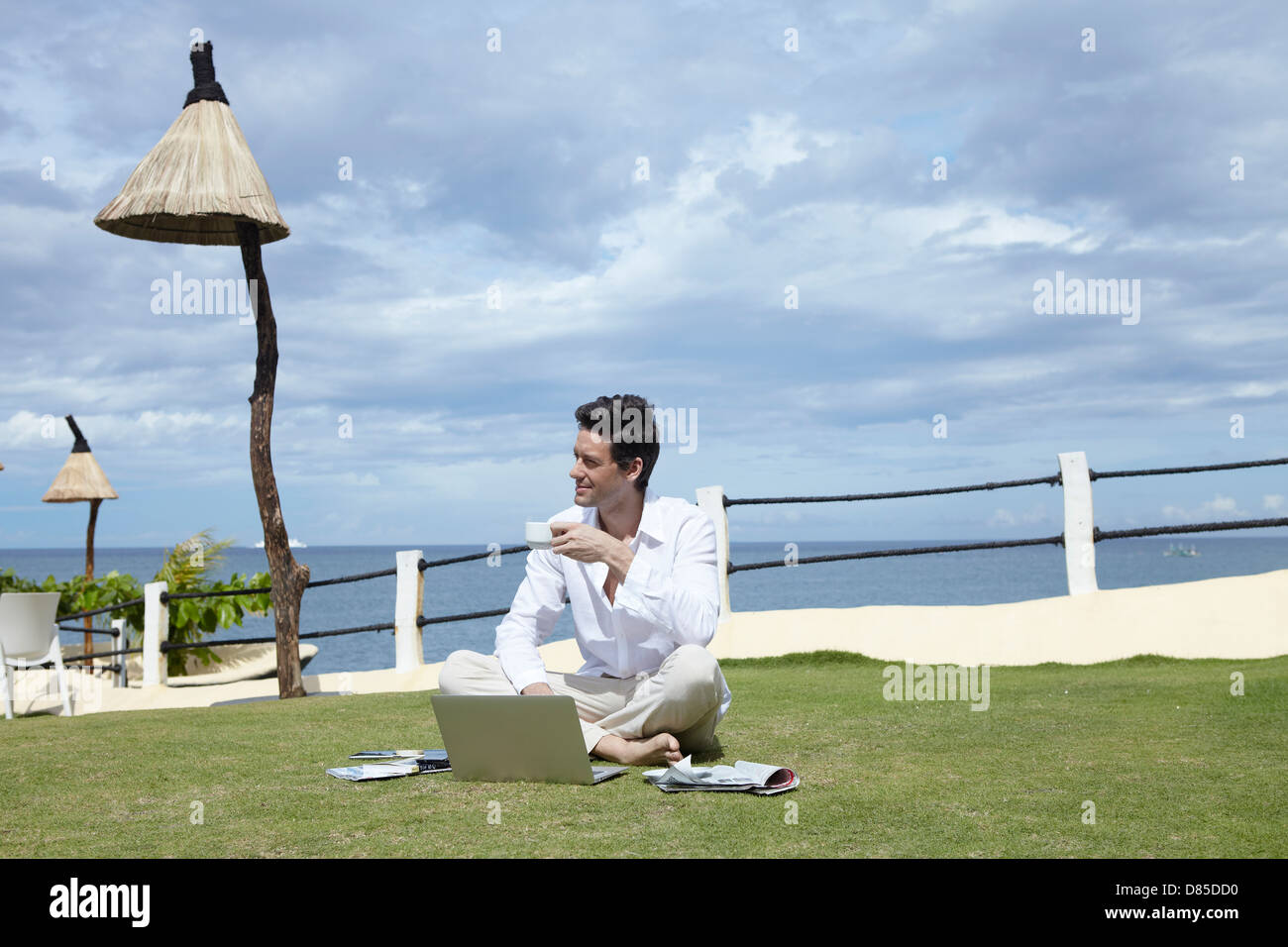 man sitting cross-legged on grass laptop Stock Photo - Alamy