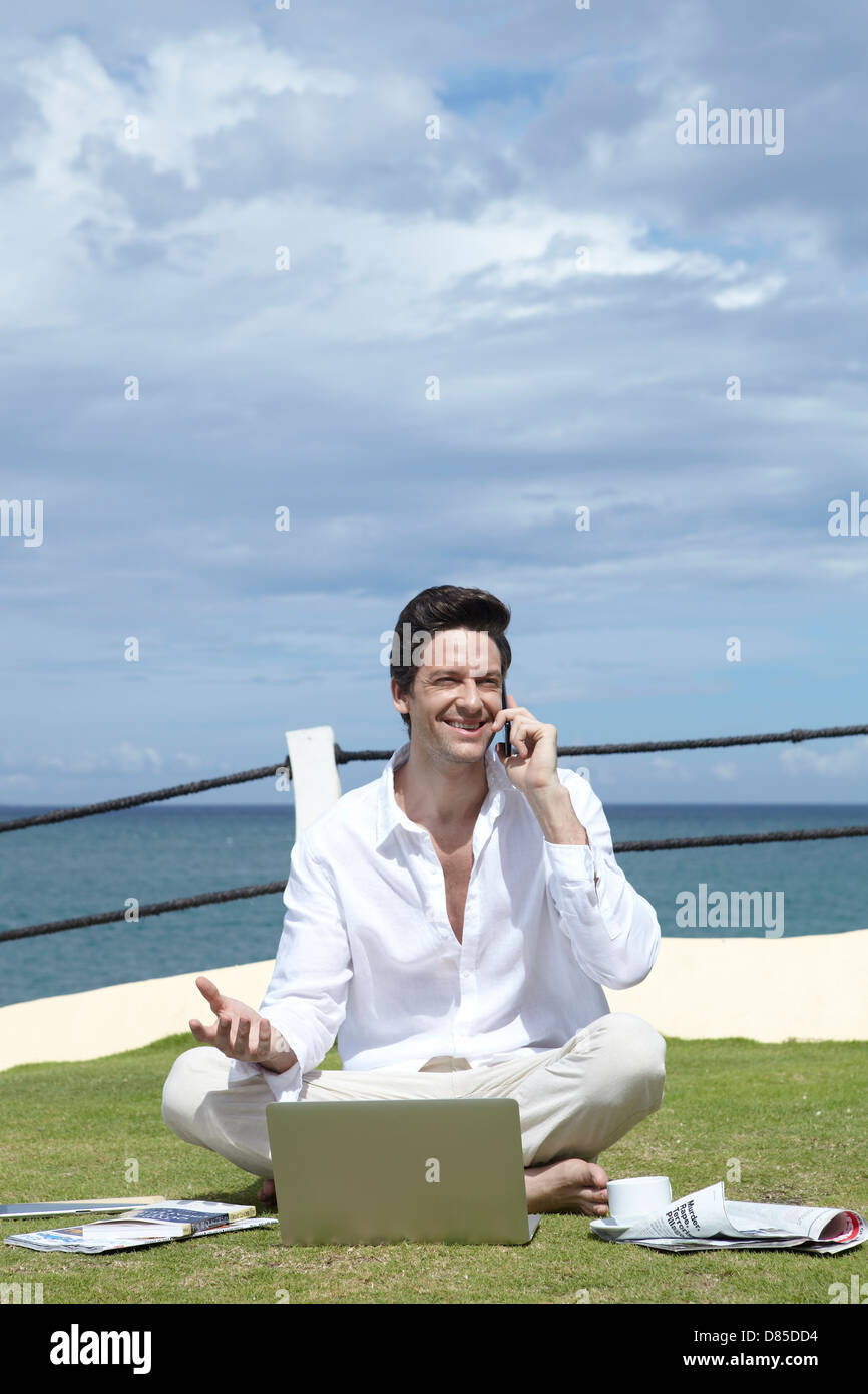 man sitting cross-legged on grass laptop Stock Photo - Alamy