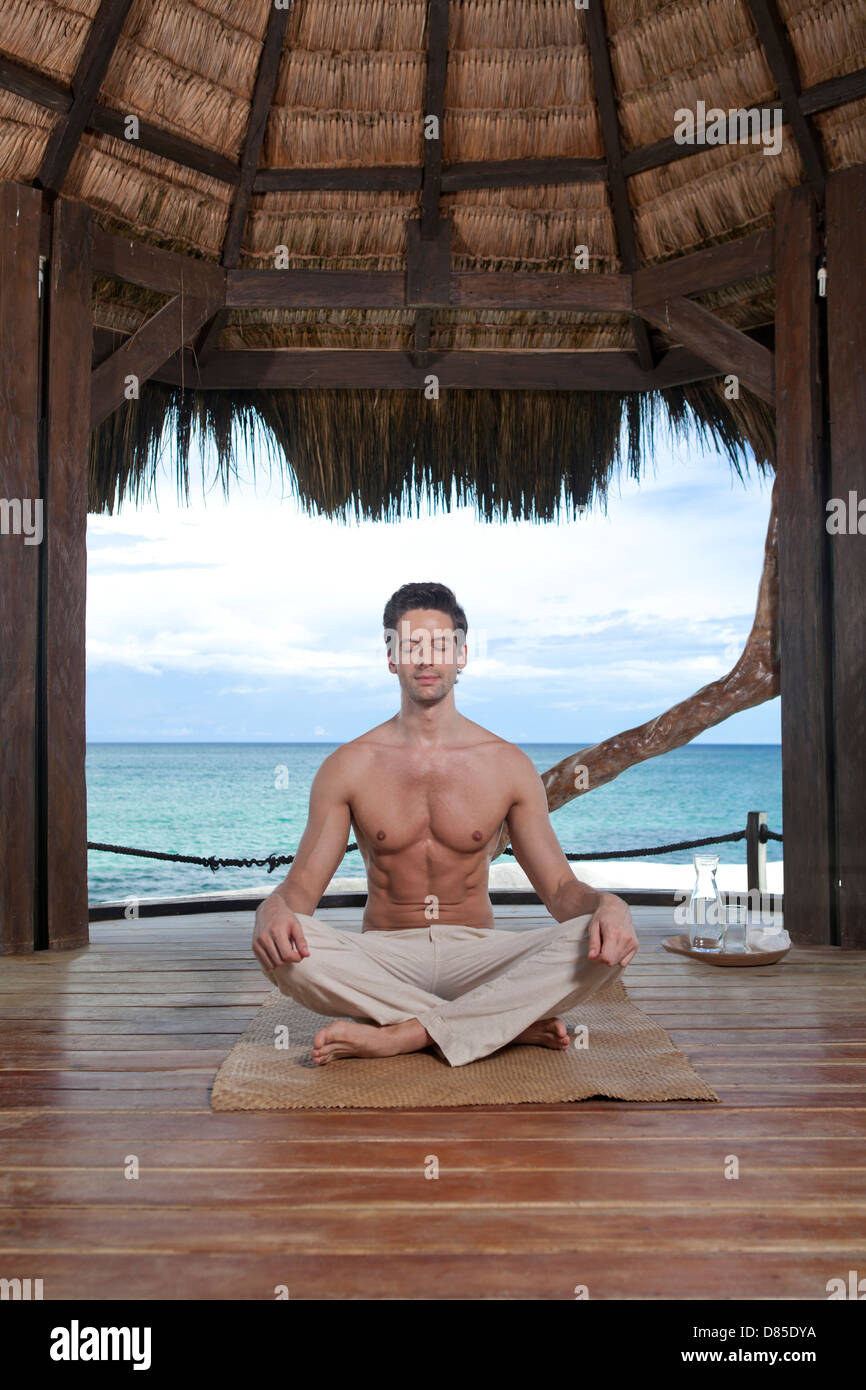 man sitting cross-legged meditating Stock Photo - Alamy