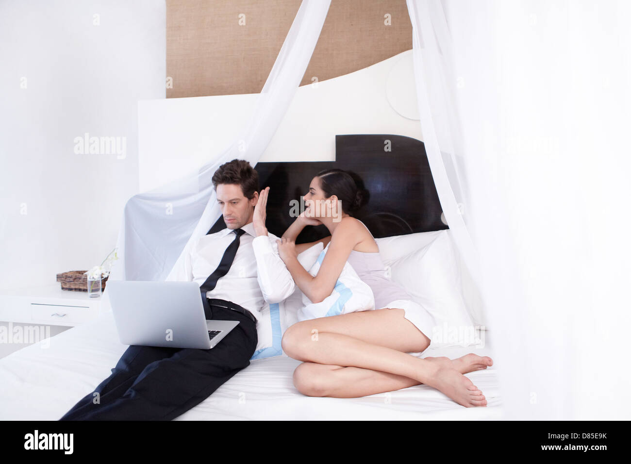 young couple sitting on bed. Stock Photo