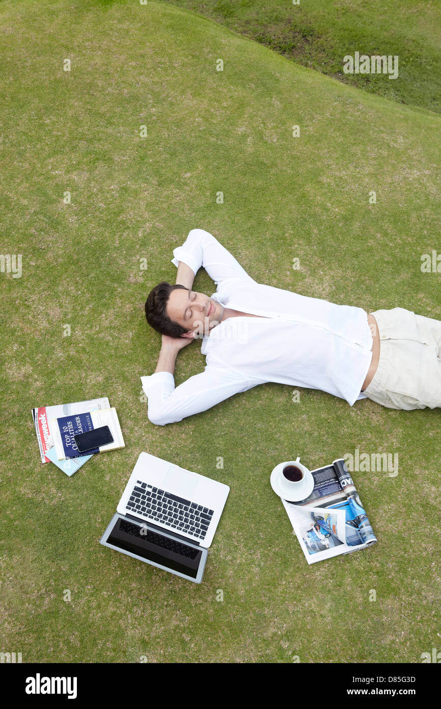 man lying on his back on grass. Stock Photo