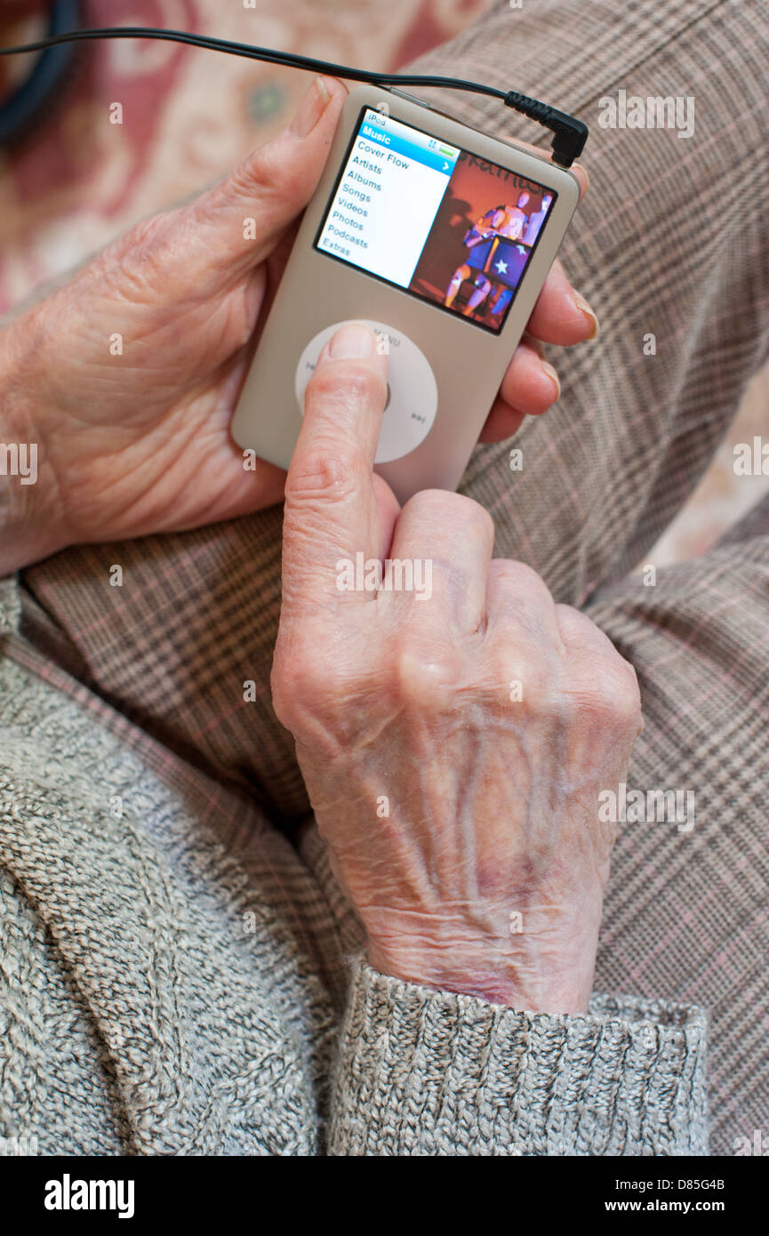 An elderly woman using an iPod Stock Photo