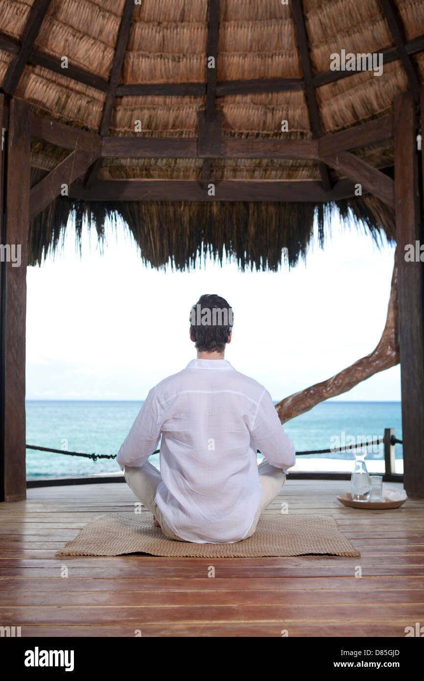 man sitting cross-legged meditating Stock Photo - Alamy