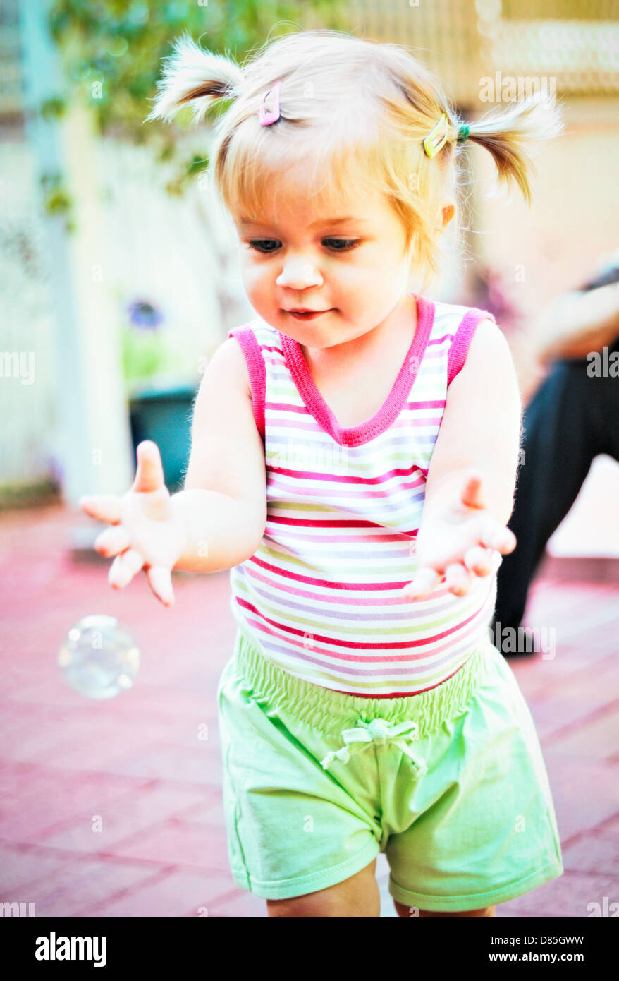 Little girl toddler chasing soap bubble Stock Photo