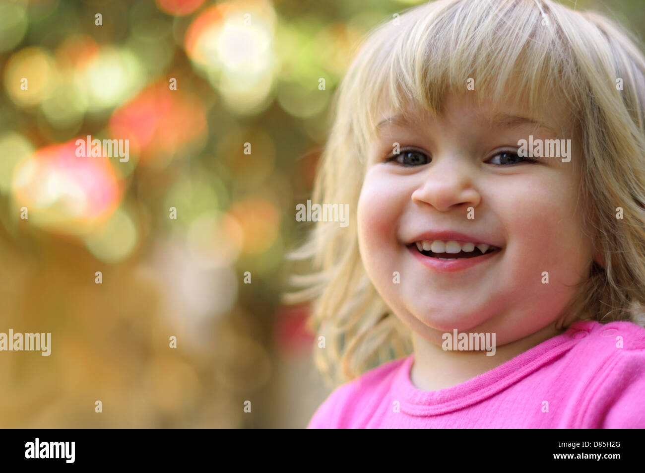 Little girl toddler laughing happily with eye contact Stock Photo