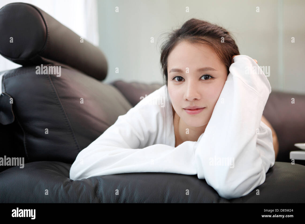 young woman sitting on sofa Stock Photo - Alamy