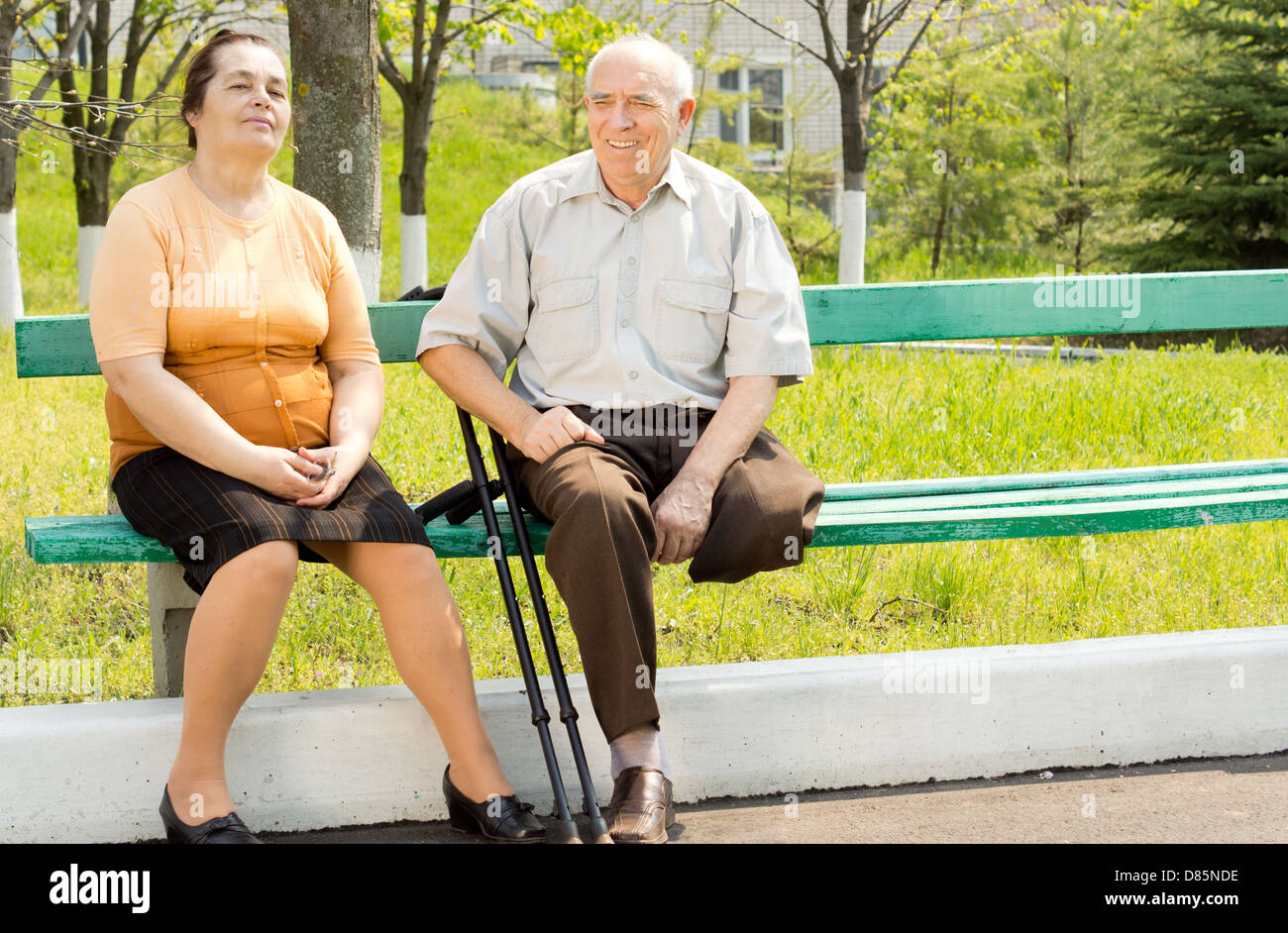 Portrait of couple talking and sitting on the park bench Stock Photo ...