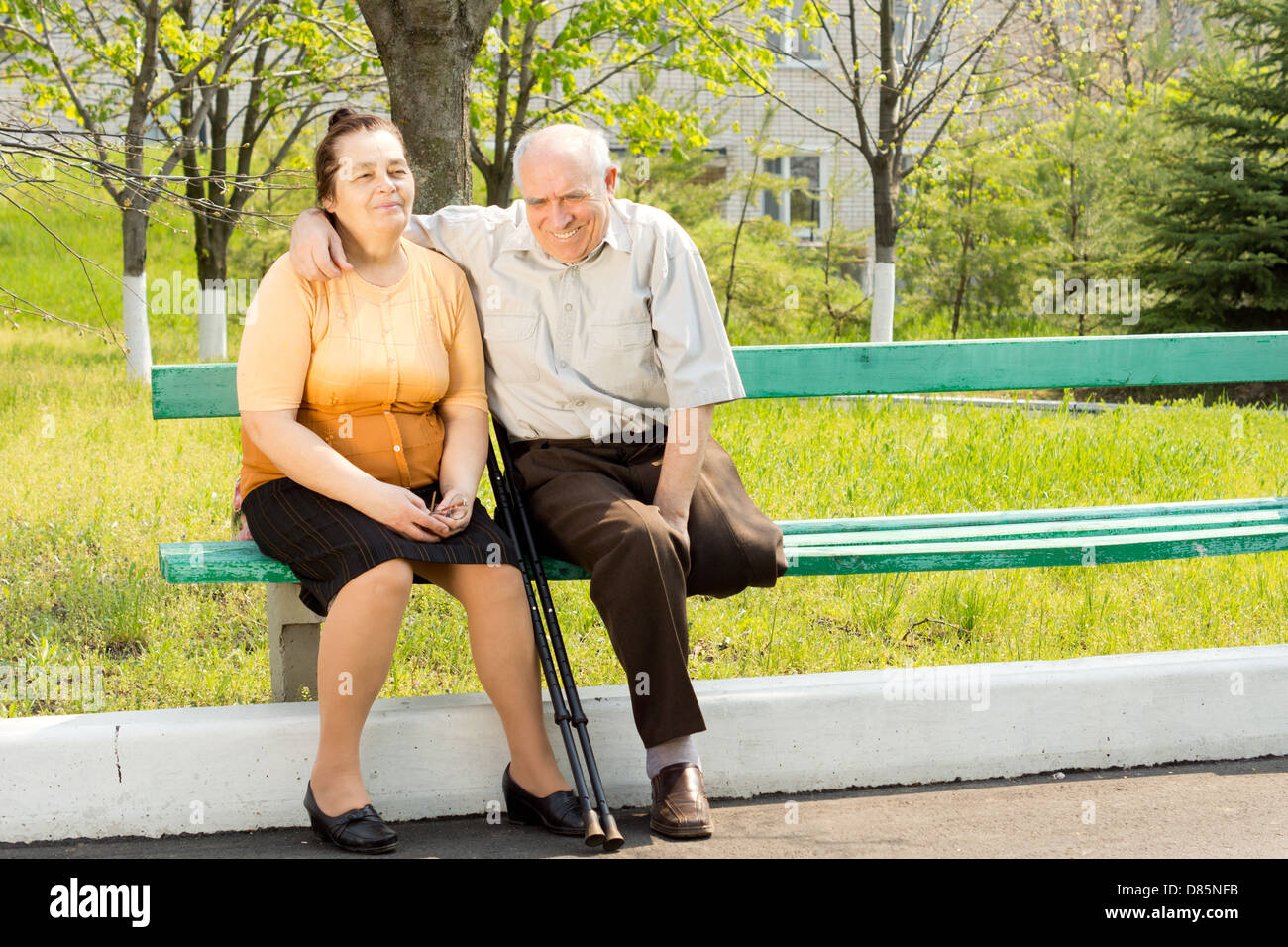 Happy couple sitting on bench and talking in the park Stock Photo - Alamy