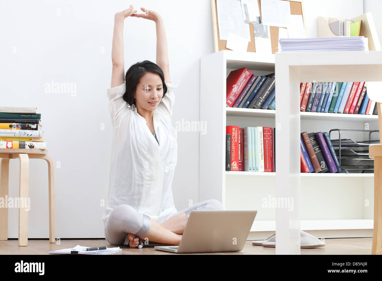 young woman sitting on floor stretching Stock Photo - Alamy