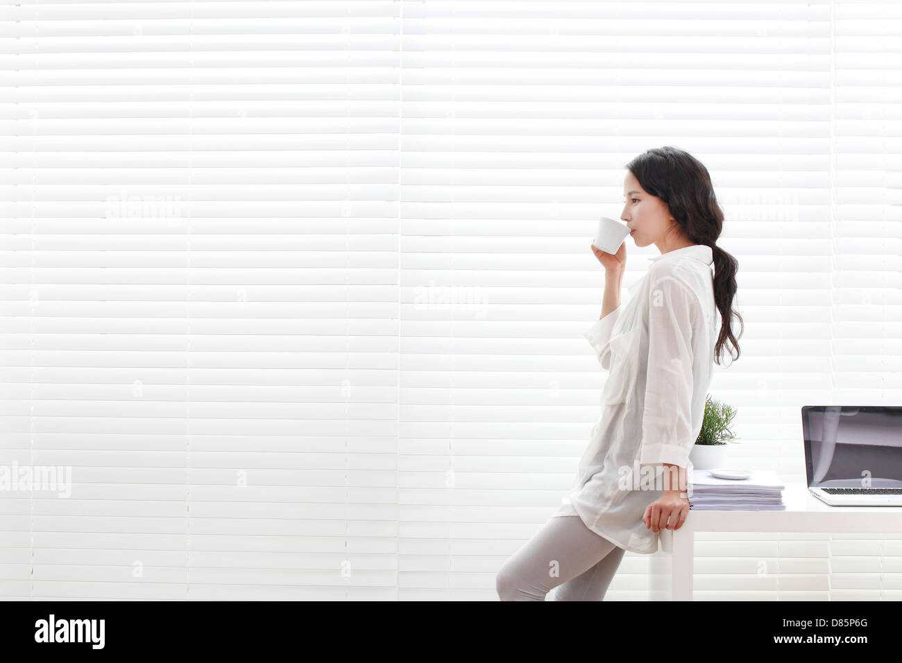 Young woman leaning against desk hi-res stock photography and images ...