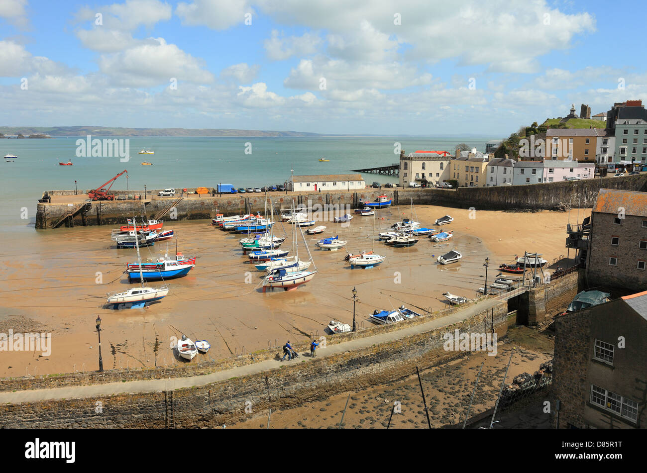 Small boats lie stranded on the sand in Tenby Harbour, West Wales, UK, at low tide. Stock Photo