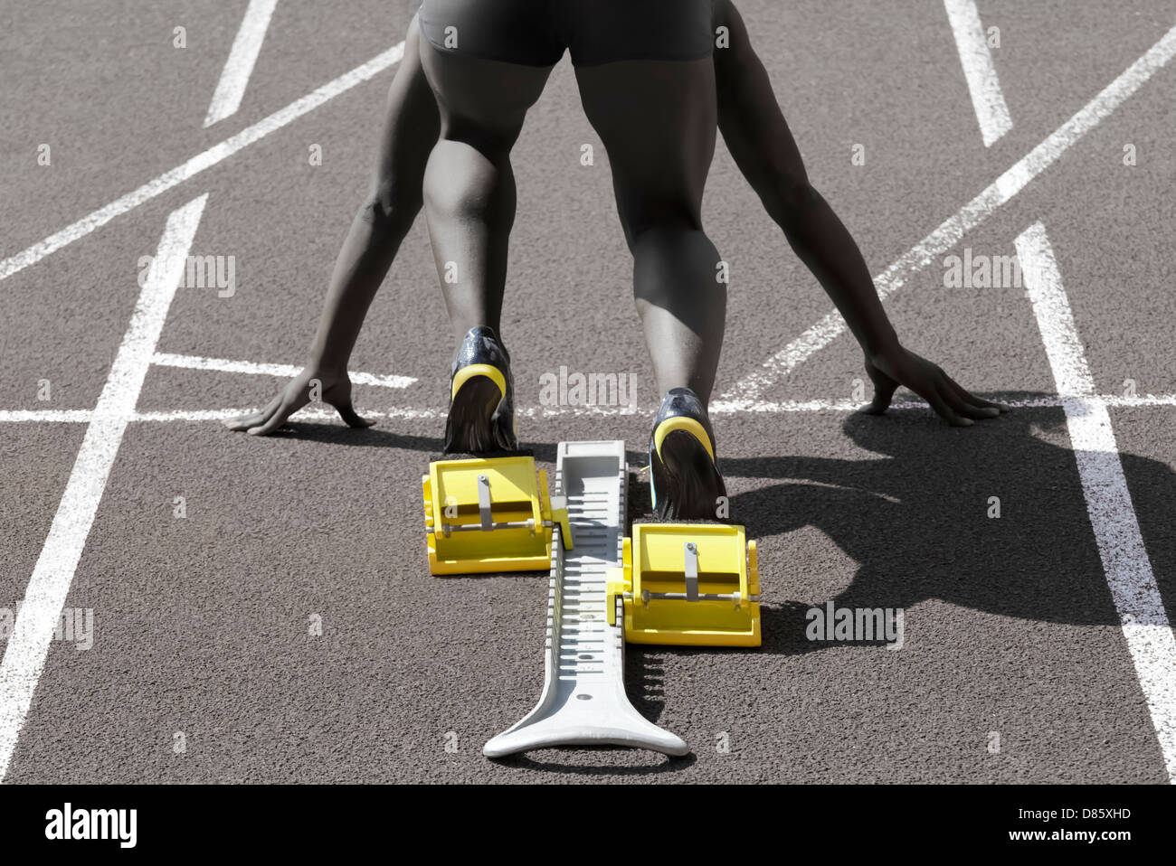 Dark-skinned sprinter in start position prepares for the start Stock Photo