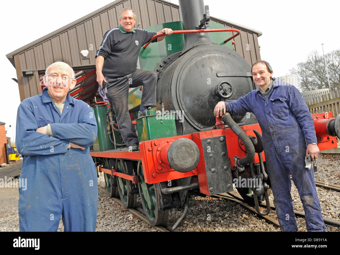 Rail enthusiasts with an old steam train that they have refurbished at