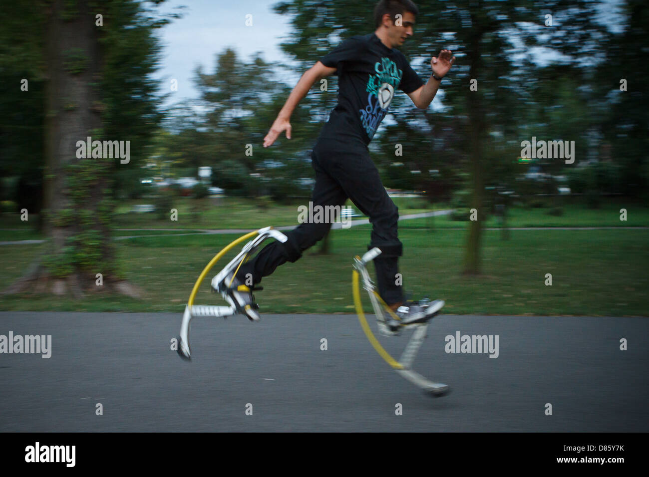 Young man running using jumping stilts Stock Photo Alamy