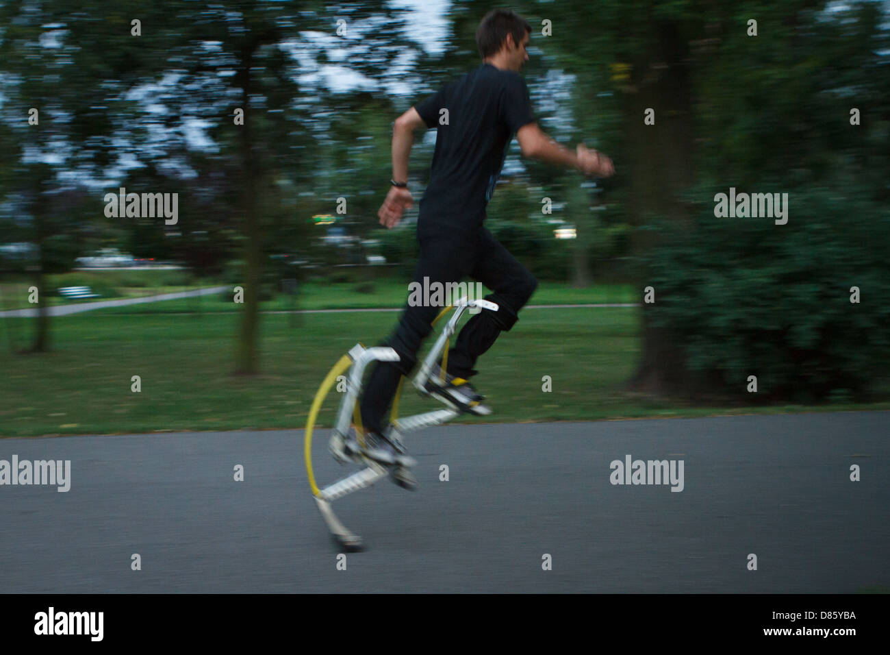 Young man running using jumping stilts Stock Photo Alamy
