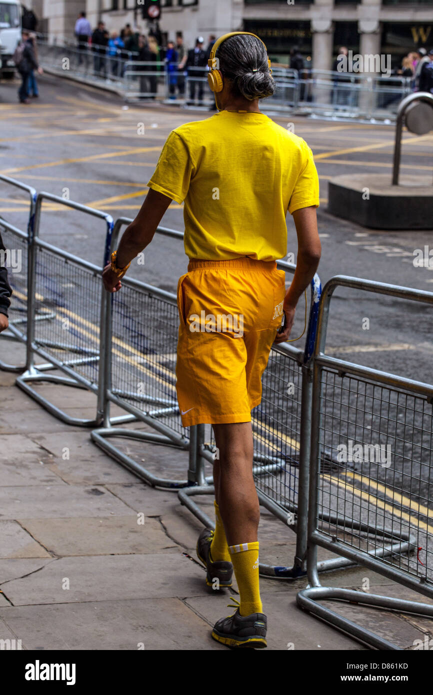 Full length rear view portrait of a funny man dressed in yellow, walking away, London, England, UK. Stock Photo