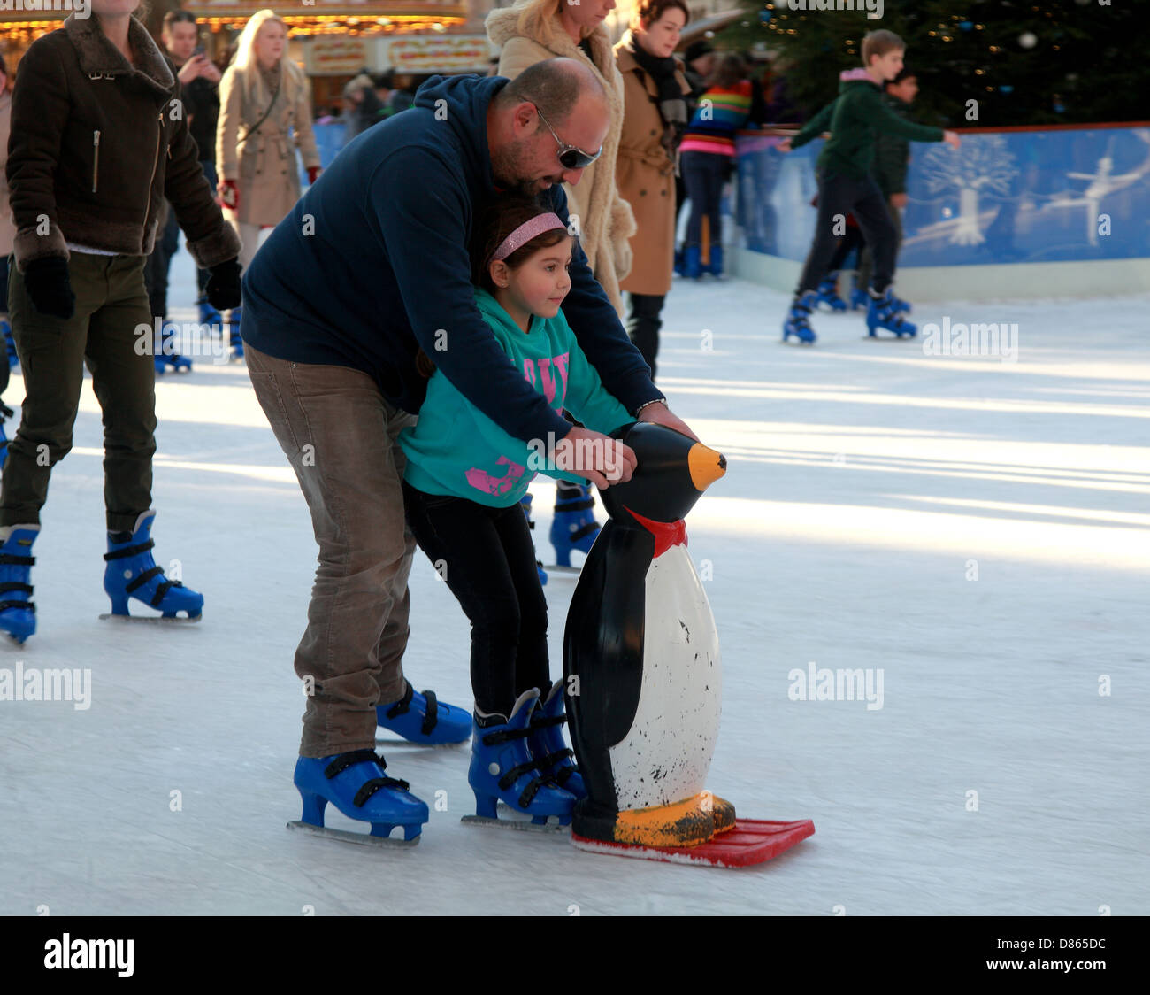 Father and Child skating at the Natural History Museum Ice Rink at Christmas . Stock Photo