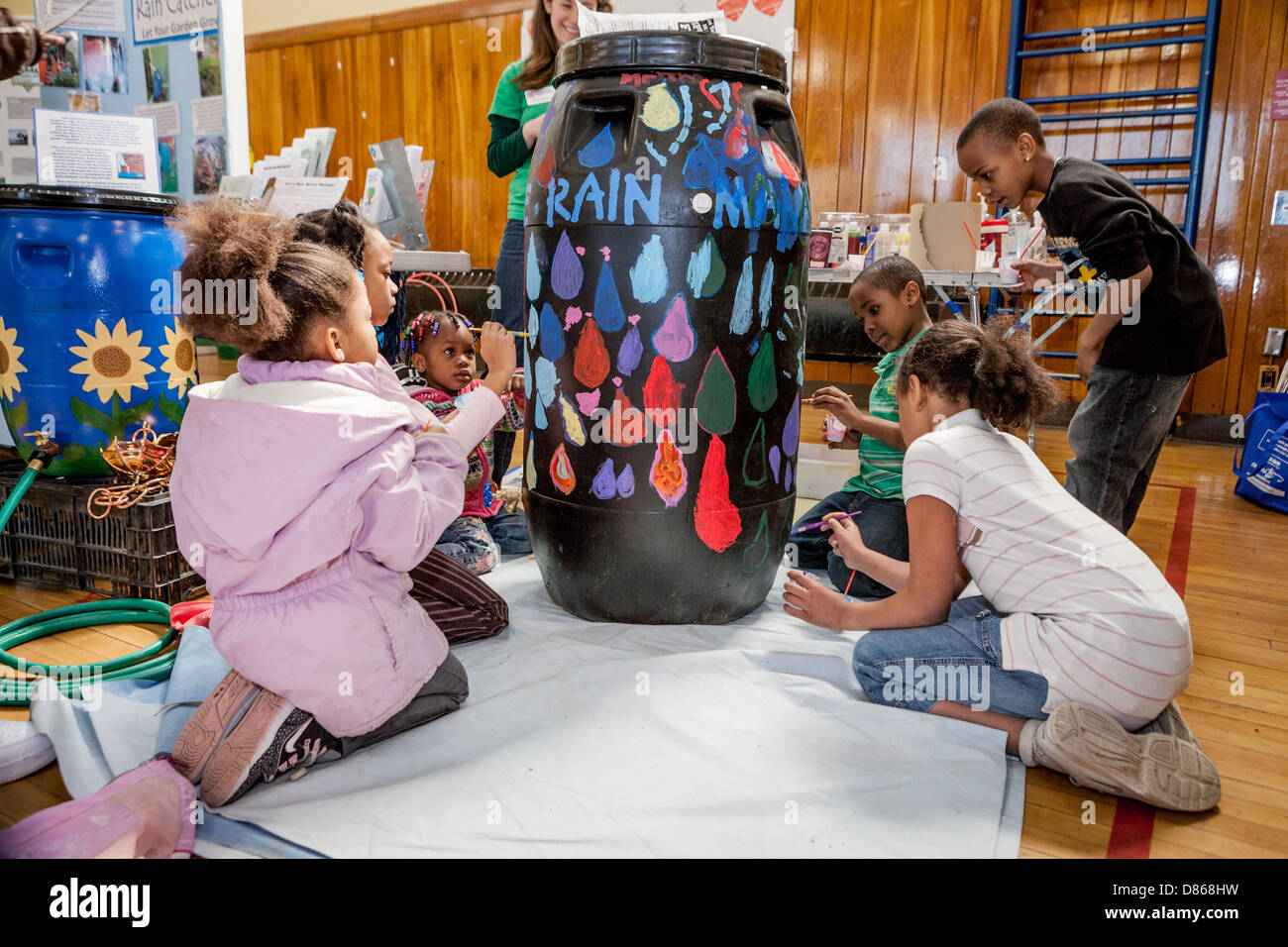 Kids paint a rain barrel, learn about water conservation at a Green Fair in Syracuse, New York Stock Photo