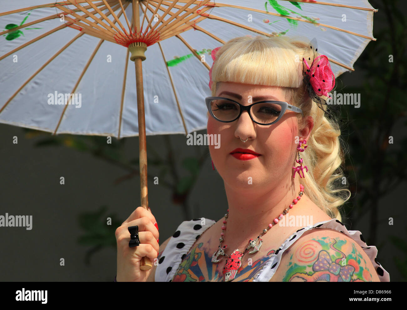 Trendy blond girl with sun umbrella seen at the annual open air art and music festival Wave-Gotik-Treffen in Leipzig, Germany. Stock Photo