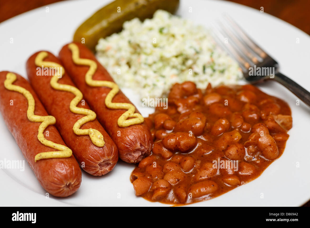 A lunch of franks and beans with cole slaw and a pickle Stock Photo Alamy