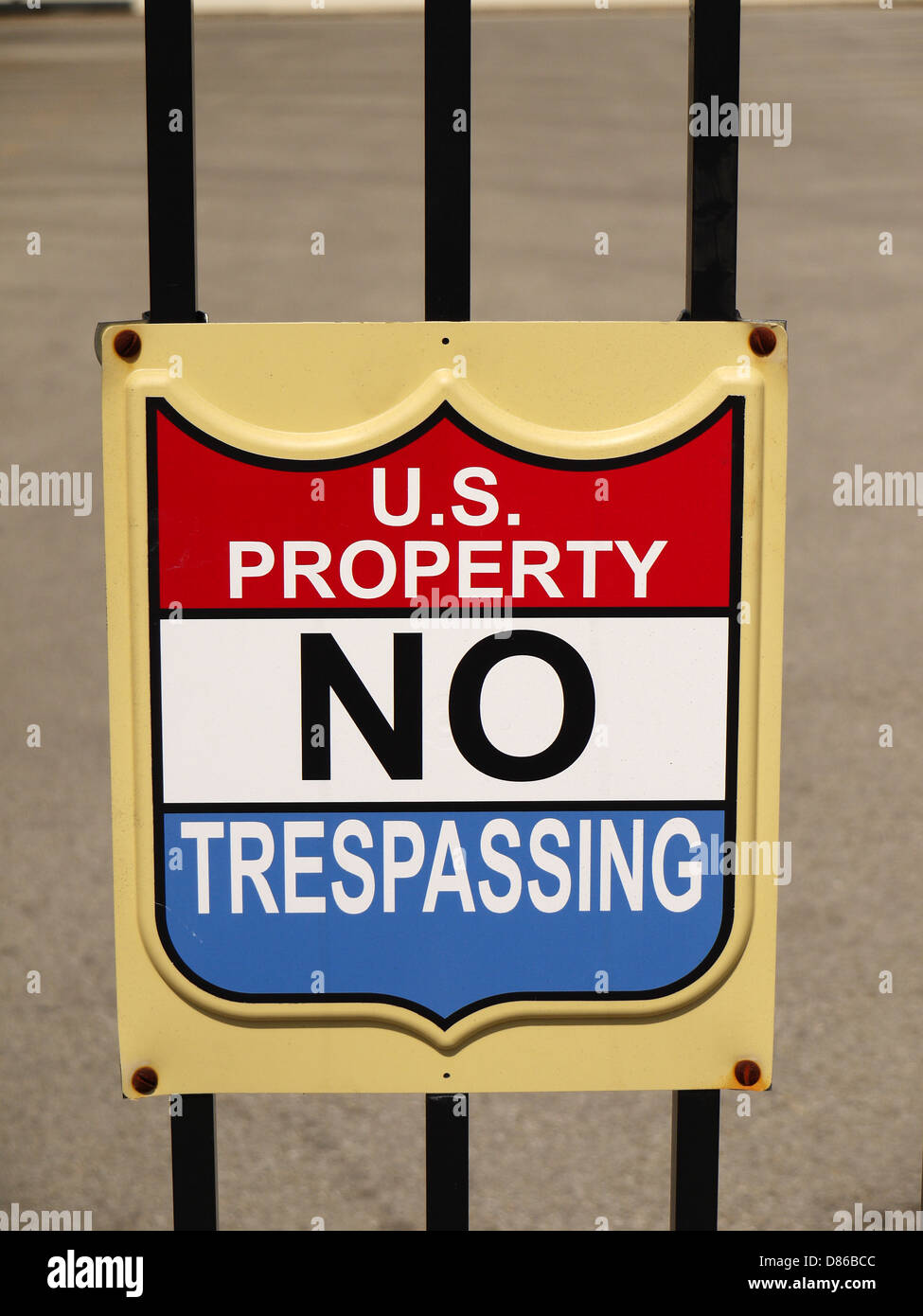 A sign posted on a fence that reads ' US Property No Trespassing' Stock Photo