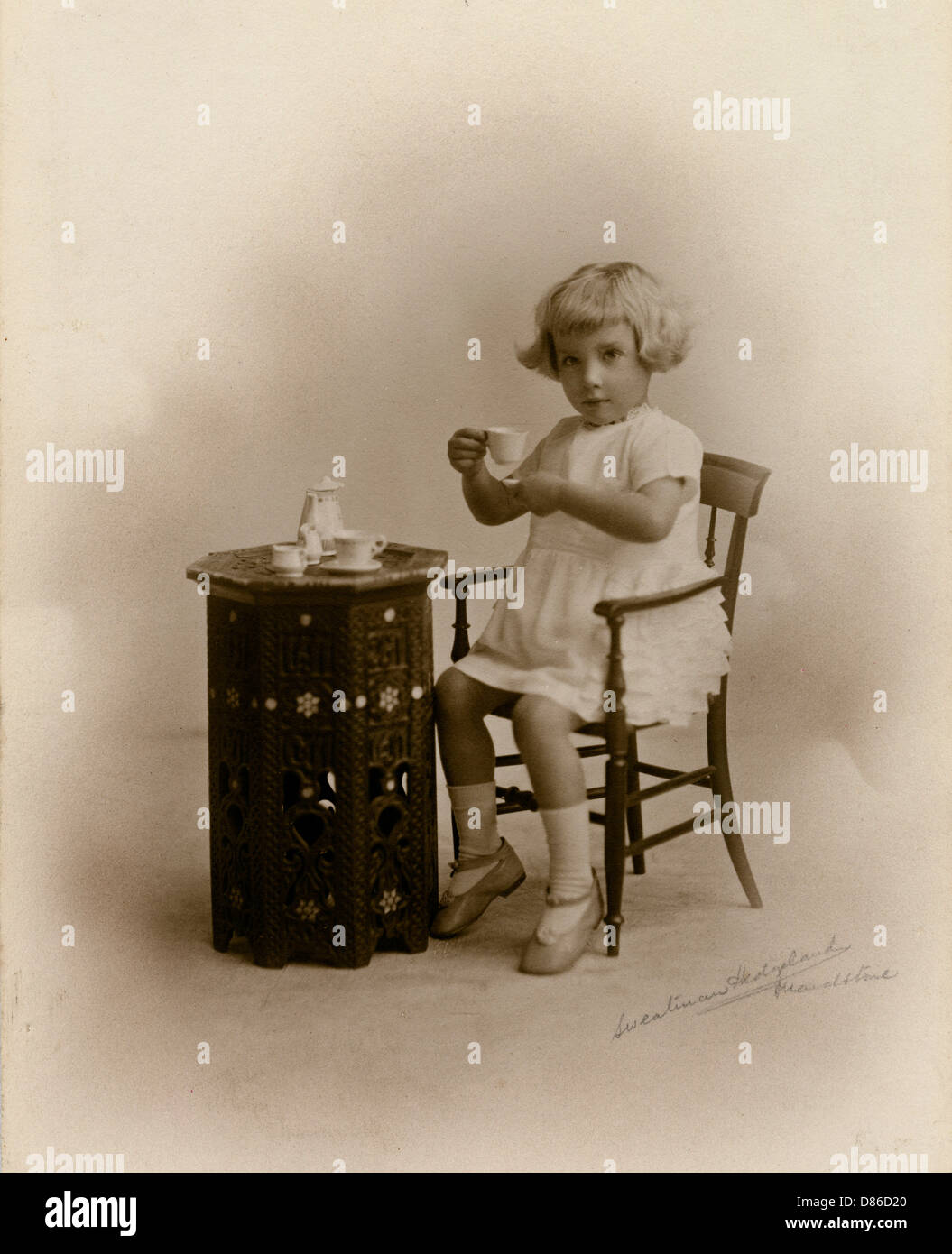 Little girl with miniature tea set Stock Photo