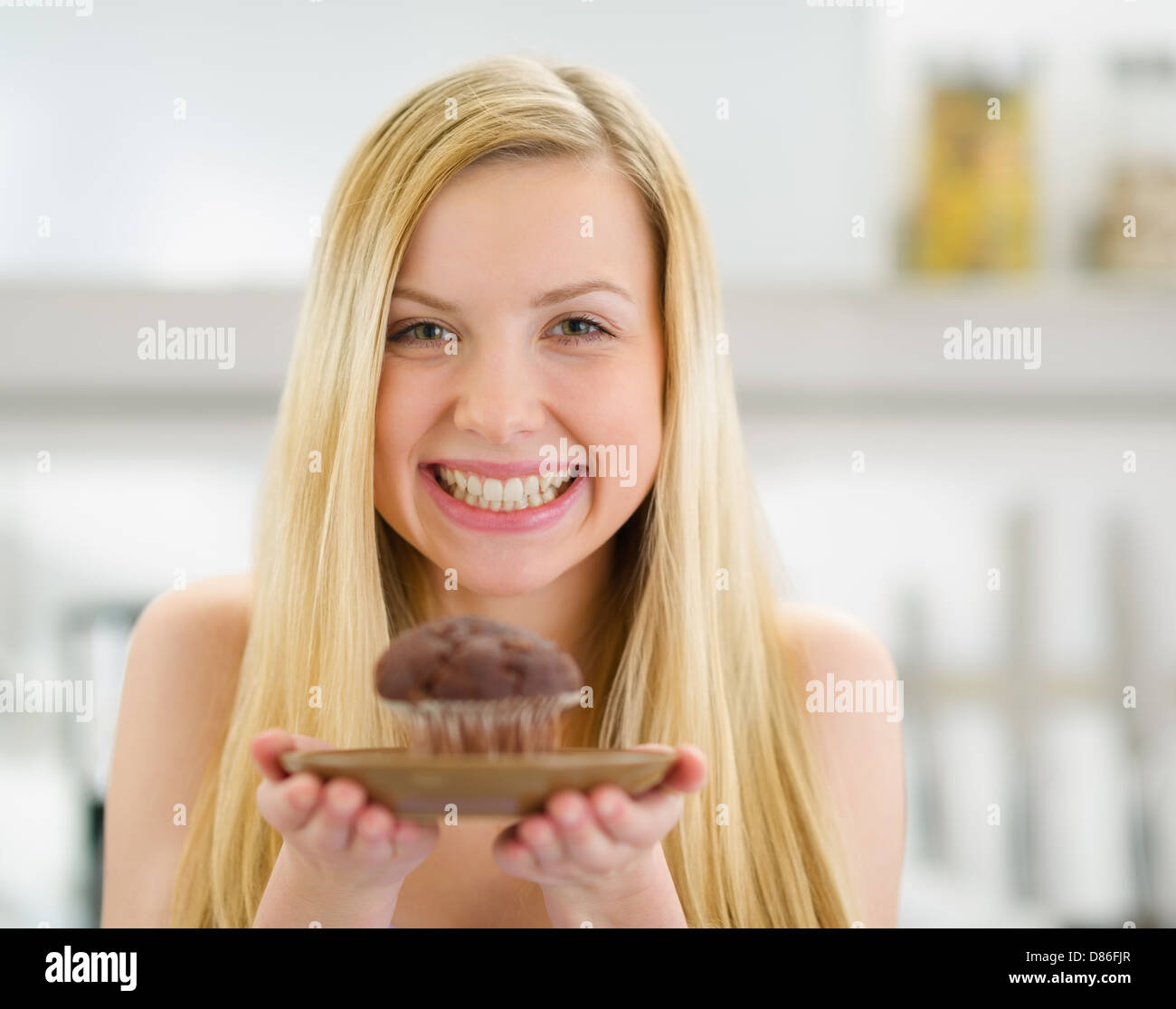 Smiling teenager girl showing chocolate muffin Stock Photo Alamy