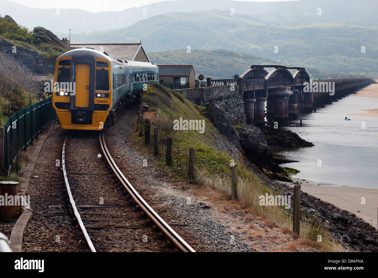 A train approaching Barmouth across the famous Barmouth railway bridge Stock Photo