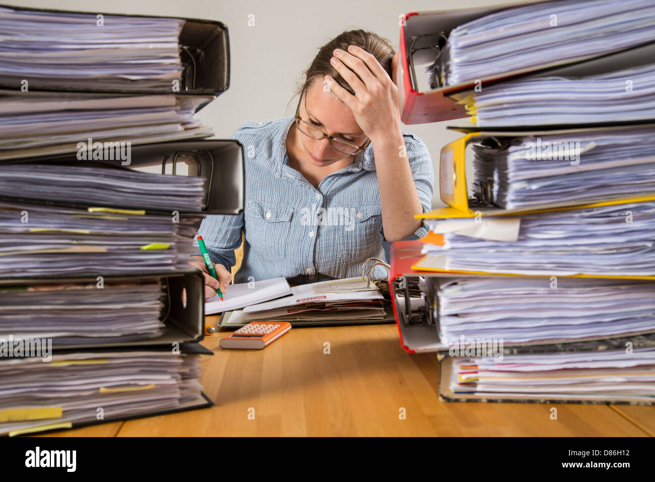 Young woman is sitting at home and sort out bills, receipts and other papers for her tax declaration. Stock Photo