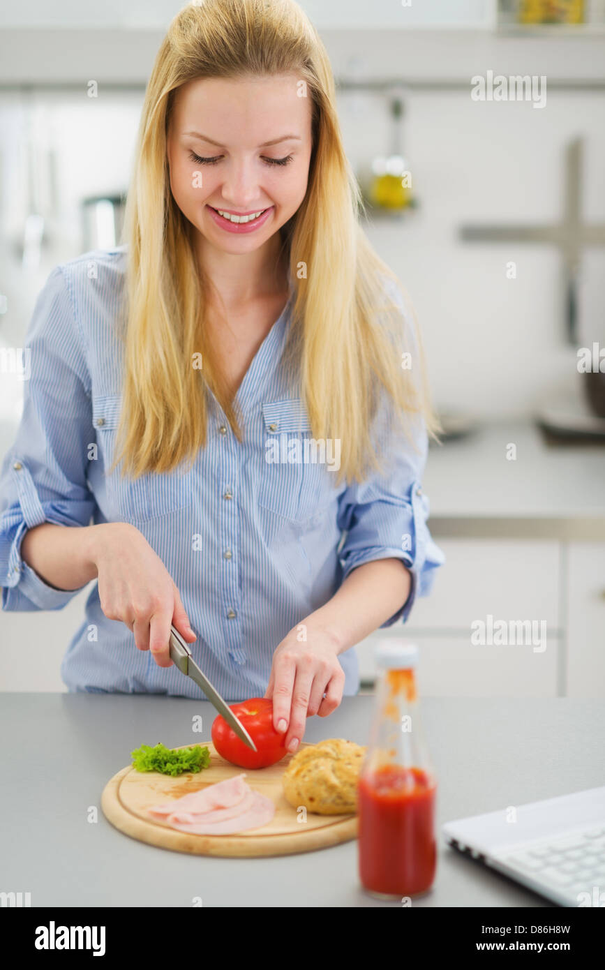 Happy teenager girl making sandwich in kitchen Stock Photo